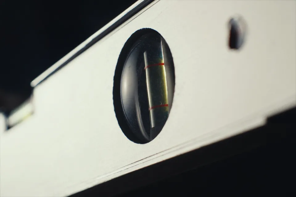 The bubble vial of a steel spirit level, sharply in focus.
